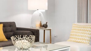 A modern living room with a sofa, a coffee table, a lamp, and decorative items.