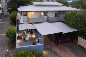 Une maison à deux étages avec un patio couvert et un garage.