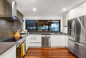 Una cocina moderna con un refrigerador de acero inoxidable, un lavavajillas y una estufa.