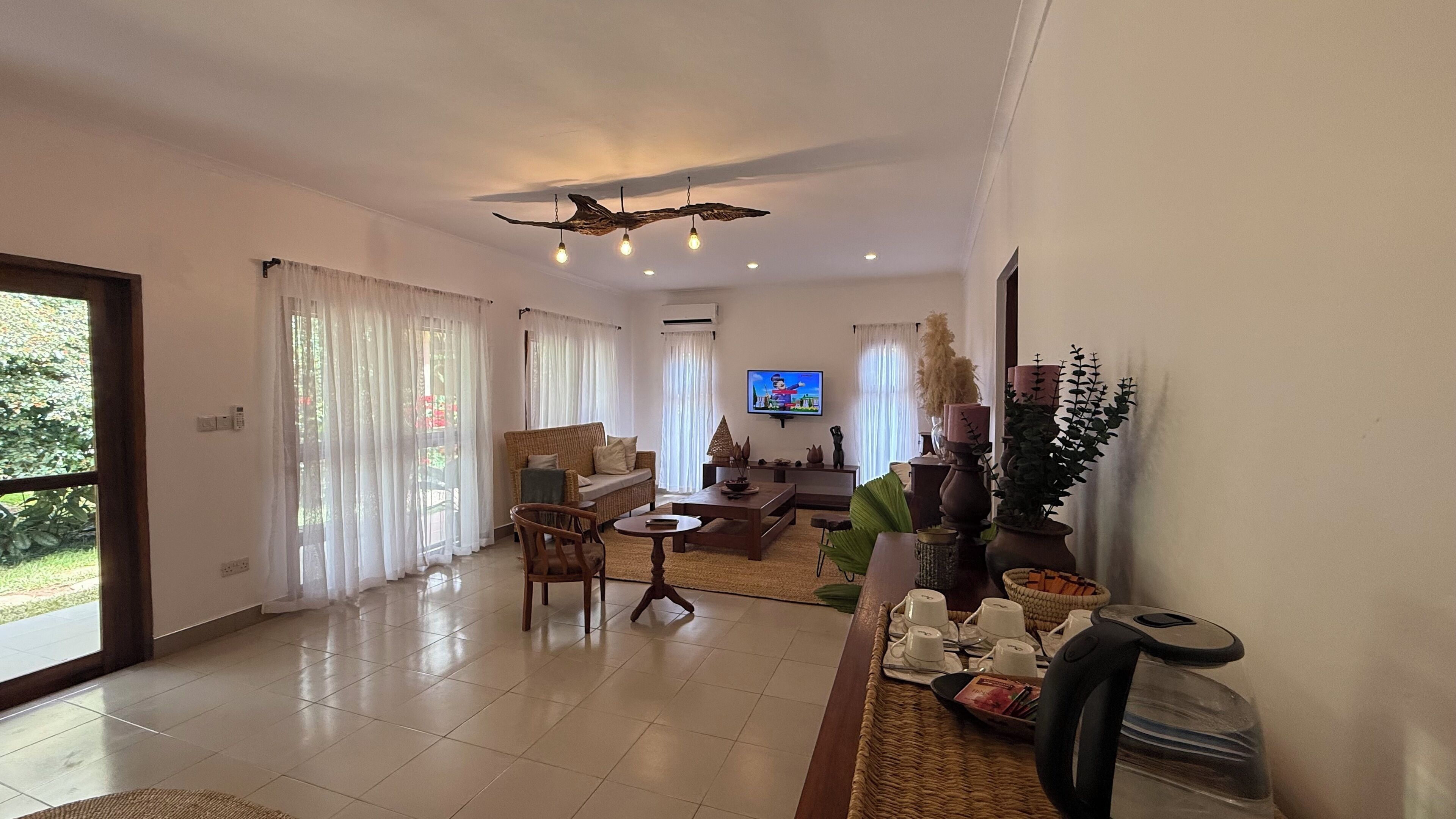 A spacious living room with a sofa, chairs, a coffee table, and a television.