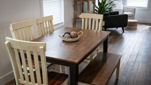 Un coin repas comprenant une table en bois, quatre chaises et un banc.