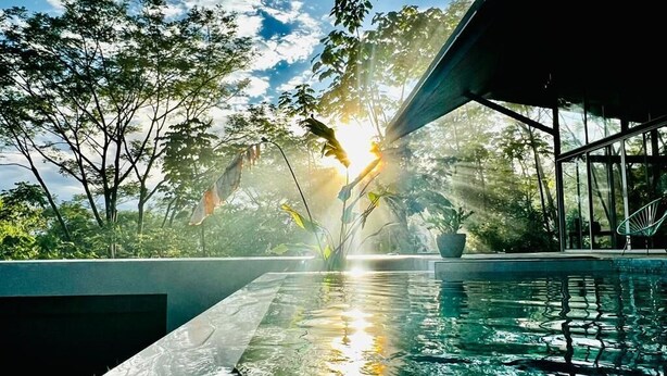 Ein Swimmingpool mit Blick auf den Himmel und die umliegenden Bäume.