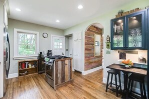 Enjoy cooking and dining in this kitchen with a central island stove and dining area featuring two bar stools.