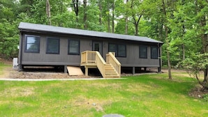 Une cabane de plain-pied avec une terrasse à l’avant et un petit escalier.