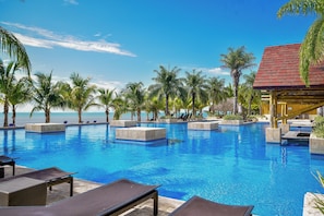 Ein Pool mit Liegestühlen und Palmen.