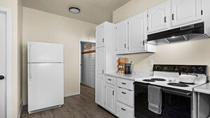 A kitchen with white cabinets, a white refrigerator, a stove, and a microwave. - 2BR Near Duluth + Spacious & Work‑Friendly (Superior)