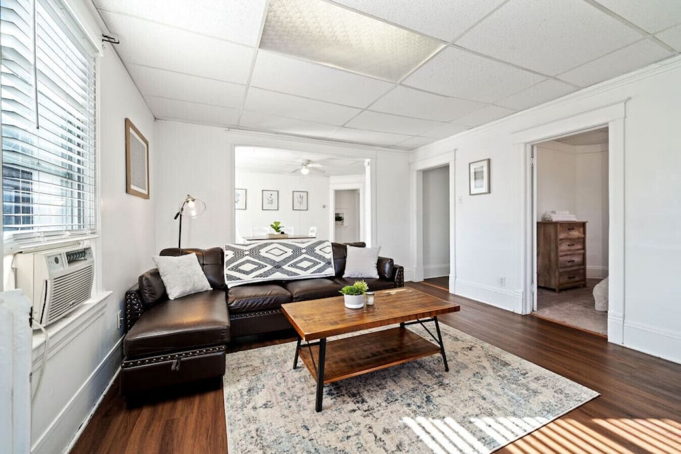 A living room with a leather sofa, a coffee table, and a patterned rug.