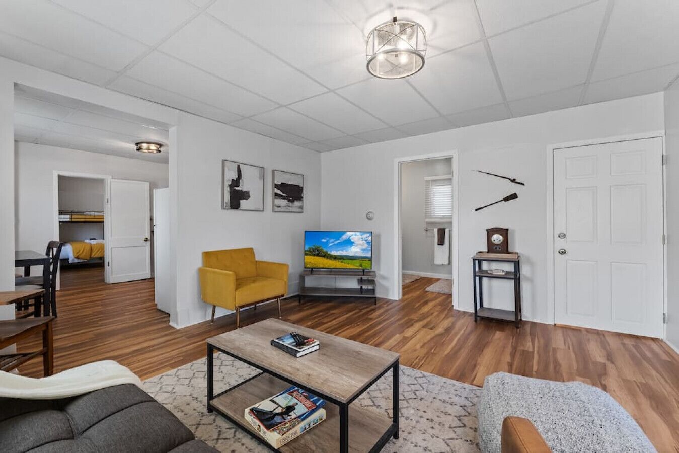 Uma sala de estar moderna com sofá, poltrona, mesa de centro e televisão.