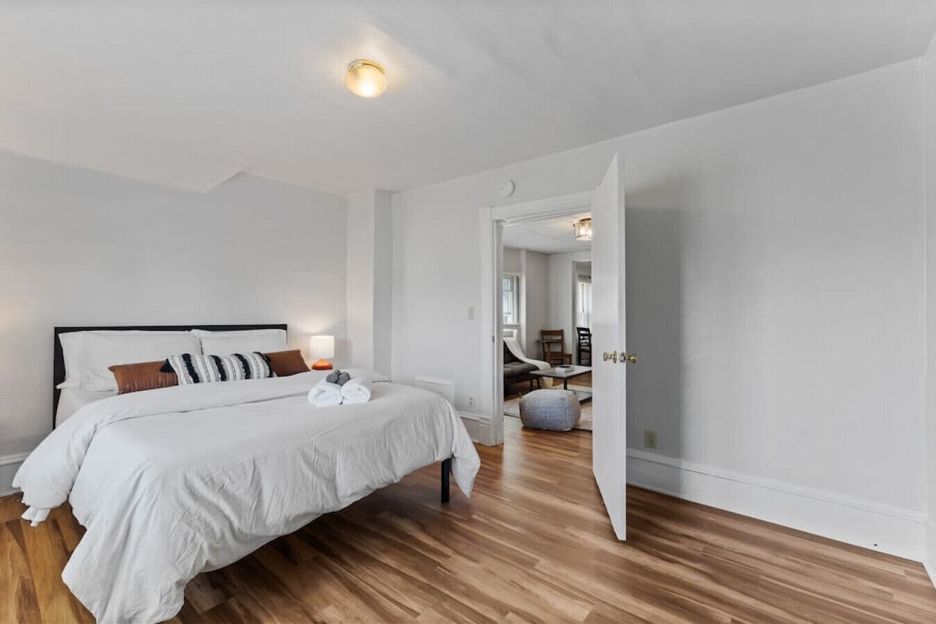 Un dormitorio moderno con una cama grande, una mesita de noche y una mesilla.