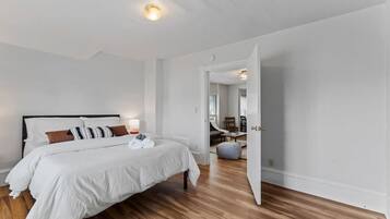 Un dormitorio moderno con una cama grande, una mesita de noche y una mesilla.