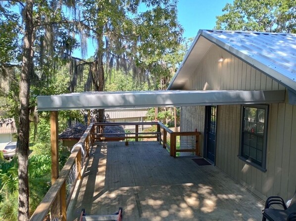 A covered deck with a wooden railing, a small table, and a bench. - Lanan Hideaway on Toledo Bend >B CLOSE TO TOLEDO TOWN!!!! (Many)