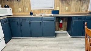 A kitchen with dark blue cabinets, a microwave, a sink, and a fire extinguisher. - Lanan Hideaway on Toledo Bend >B CLOSE TO TOLEDO TOWN!!!! (Many)