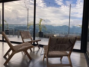 Un balcon avec des fauteuils en osier et une vue sur les montagnes.