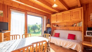 A cozy cabin with a dining area, a sofa with red pillows, and a television. - wonderful Chalet 6 ppl, mountain view (Morillon)
