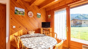 A wooden cabin interior with a dining table, chairs, a television, and artwork on the walls. - wonderful Chalet 6 ppl, mountain view (Morillon)