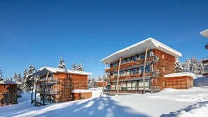 A modern ski resort building with multiple balconies and a ski lift visible. - Appartement 6 pers, vue montagne avec terrasse (Chamrousse)