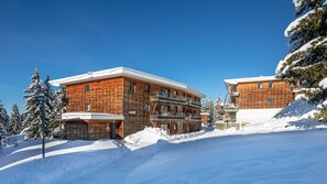 A modern wooden lodge with a ski lift, surrounded by snow-covered trees. - Appartement 6 pers, vue montagne avec terrasse (Chamrousse)