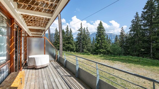 A wooden deck with a table and chairs, overlooking a forest and mountains. - Superbe logement 6 pers à Chamrousse (Chamrousse)