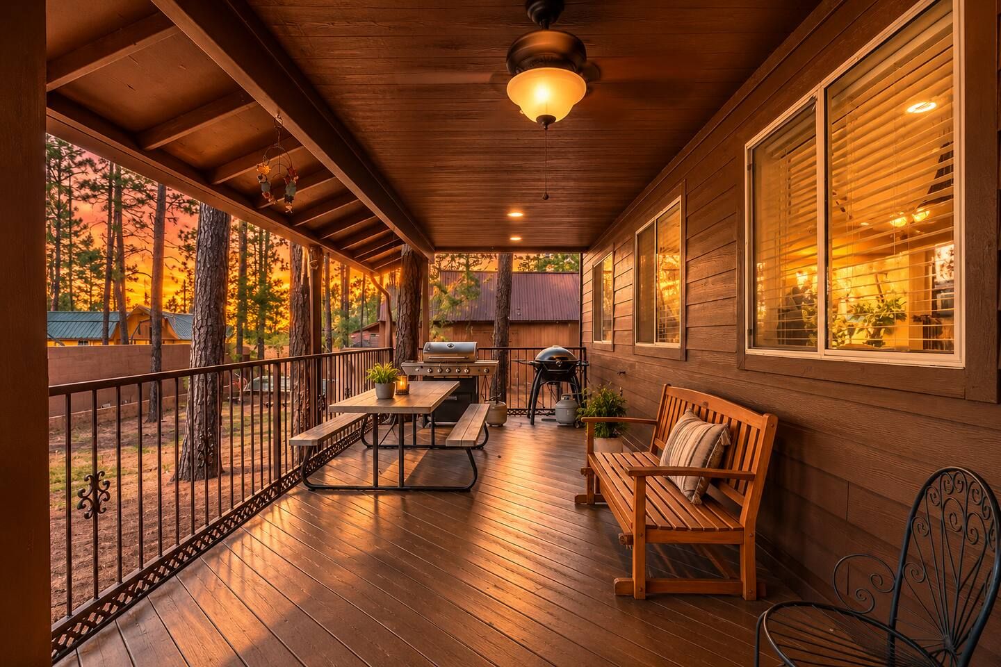 Un espace extérieur abrité, doté d’une terrasse en bois, d’un barbecue, d’une table avec des bancs et d’une rambarde.