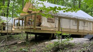 Eine Holzhütte mit Balkon, umgeben von Bäumen.