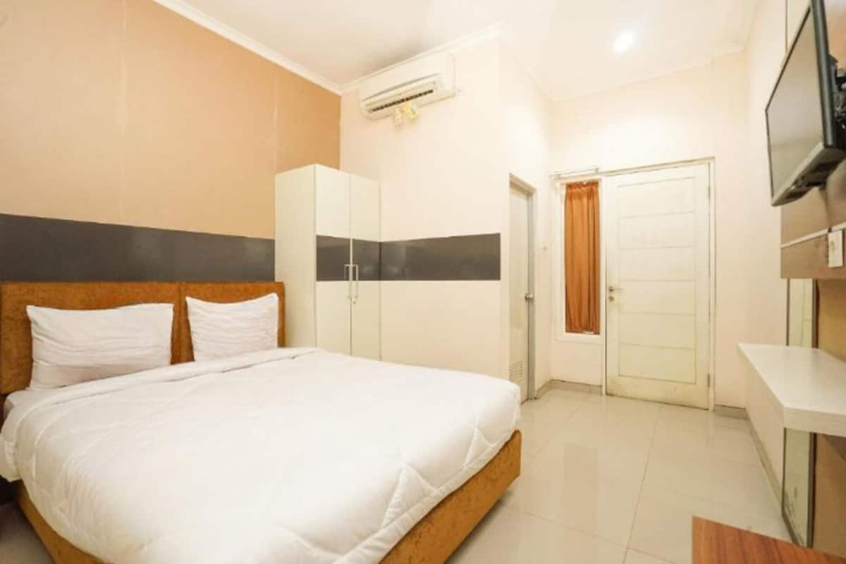 A hotel room with a bed, wardrobe, and a TV.