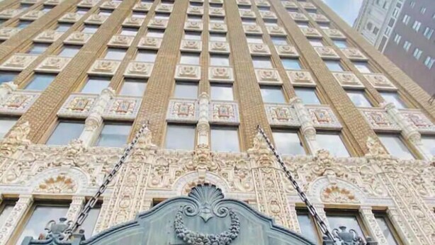 A tall building with a decorative facade and a large arched entrance. - Spacious Designer Apartment Downtown Tulsa-Gym Access (Tulsa)