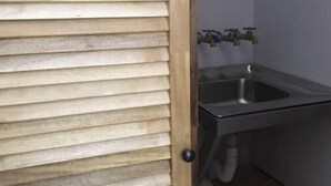 Ein Badezimmer mit Holztür, Waschbecken und Handtuchhalter.