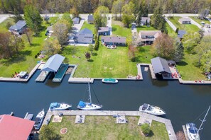 An aerial view of a residential area with houses, a dock, and boats. - BEAUTIFUL WATER FRONT AND BOATER LOVER (Orillia)