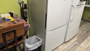 A kitchen with a refrigerator, a trash bin, and a table with a tablecloth. - Room in house (Lake Andes)