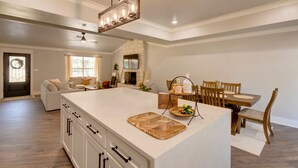 Una cocina amplia con una isla grande, mesa de comedor de madera y sillas.