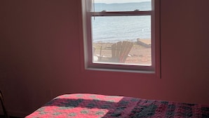 A room with a window overlooking a beach. - Beautiful, waterfront home located on the St Mary’s River, fisherman’s dream  (De Tour Village)
