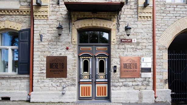 Ein Steinhaus mit einer Doppeltür, zwei Schildern mit der Aufschrift "MERE PST 8 ENDOVER" und einem Schild mit der Aufschrift "MERE PST 8".