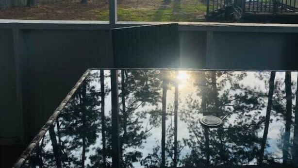 Habitación con vista a un lago y árboles.