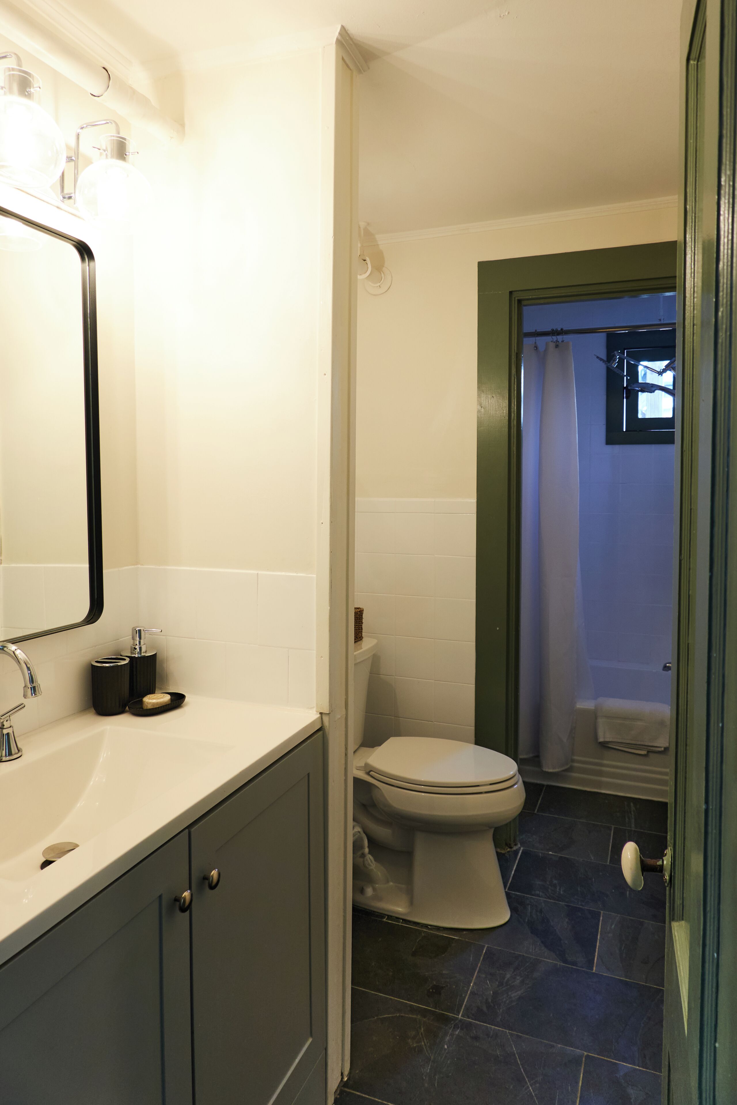 Une salle de bain avec un lavabo blanc, des toilettes et un espace douche.