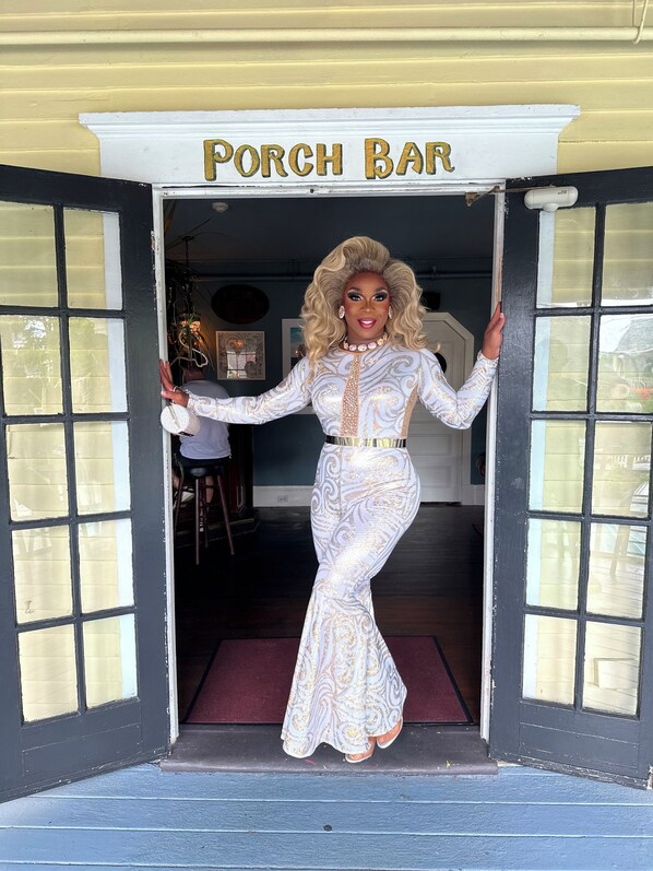 A person standing at the entrance of a building labeled "Porch Bar". - Inn at Gifford House (Provincetown)