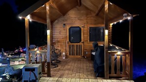 Une cabane en bois avec une véranda, une fenêtre et une porte.