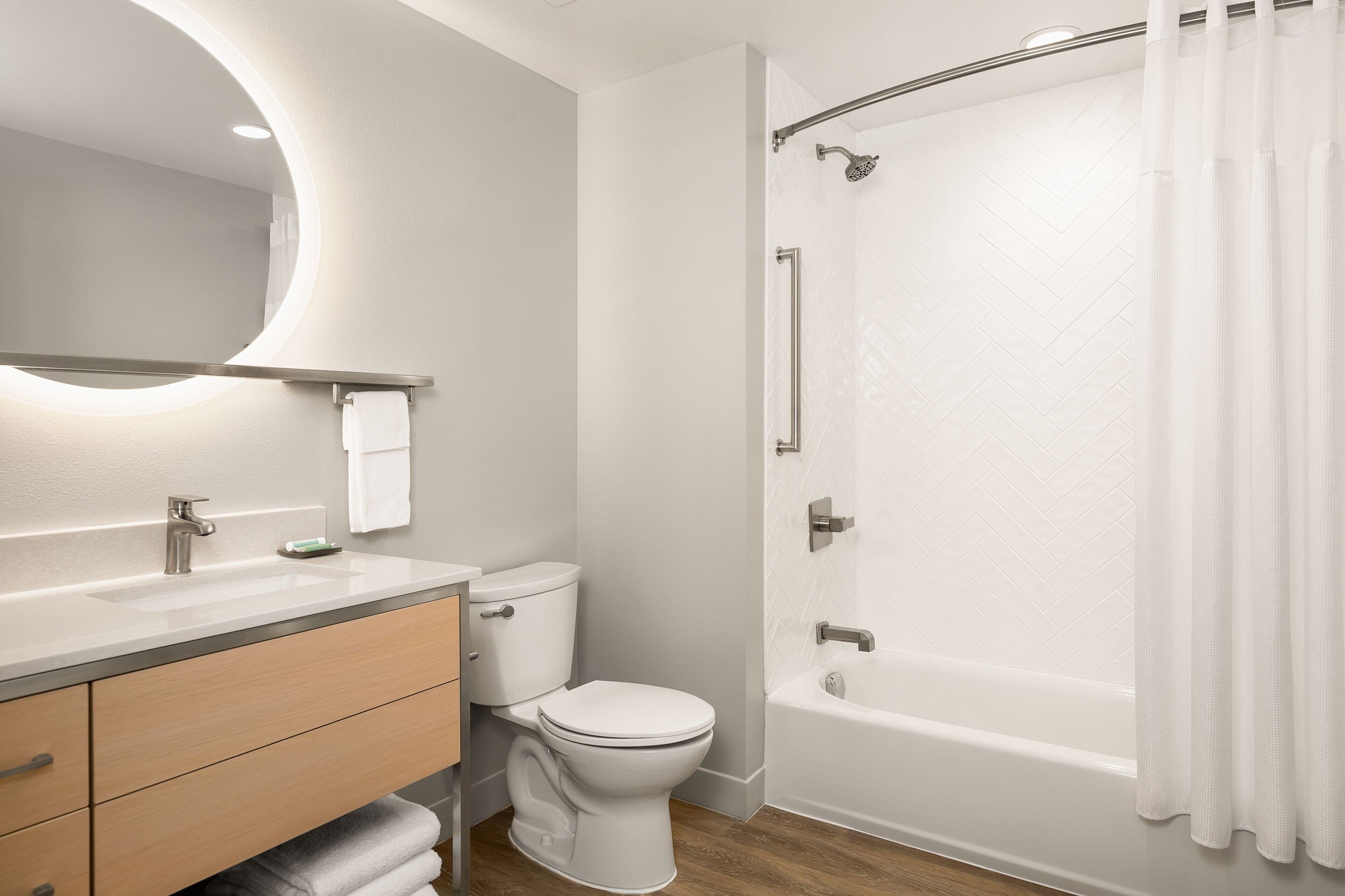 Ein modernes Badezimmer mit Toilette, Waschbecken und Badewanne.