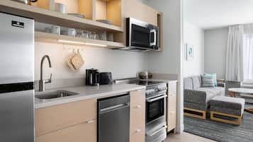 A modern kitchen with stainless steel appliances, wooden cabinets, and a built-in oven.