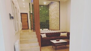 Un pasillo con una escalera que conduce a una sala de estar con un sofá y una mesita de centro.