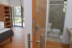 Enjoy a comfortable stay in this spacious room with a large bed, bathroom, and a window offering a view of the outdoors.