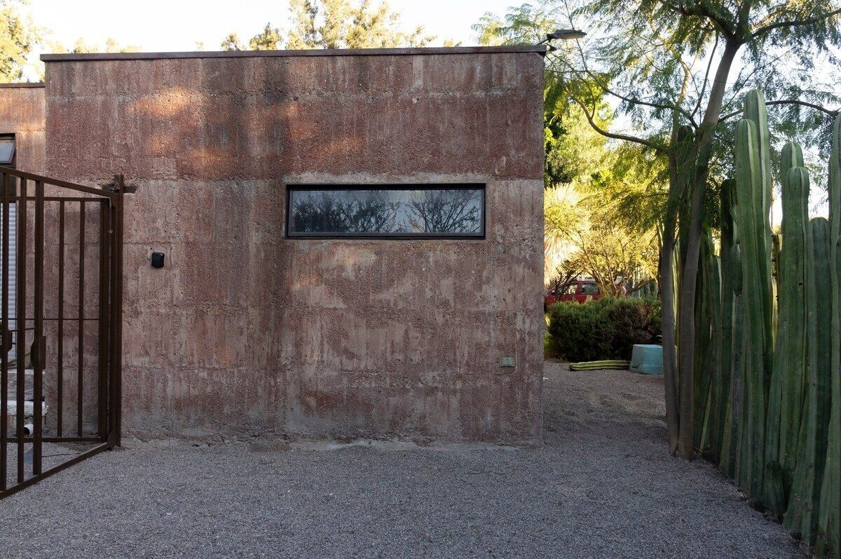 A concrete structure with a metal gate and a rectangular window.