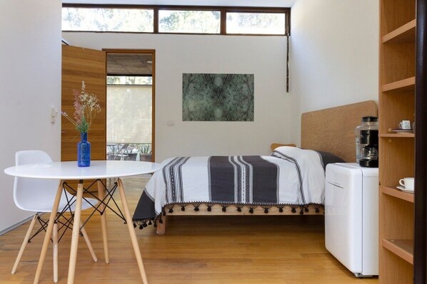 Cozy retreat with a single bed, bedside table, and a large window offering a view.