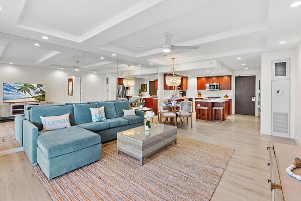 A spacious living area with a blue sofa, a coffee table, and a kitchen in the background. - Grdn View steps from beach, dining, shopping 270 (Lahaina)
