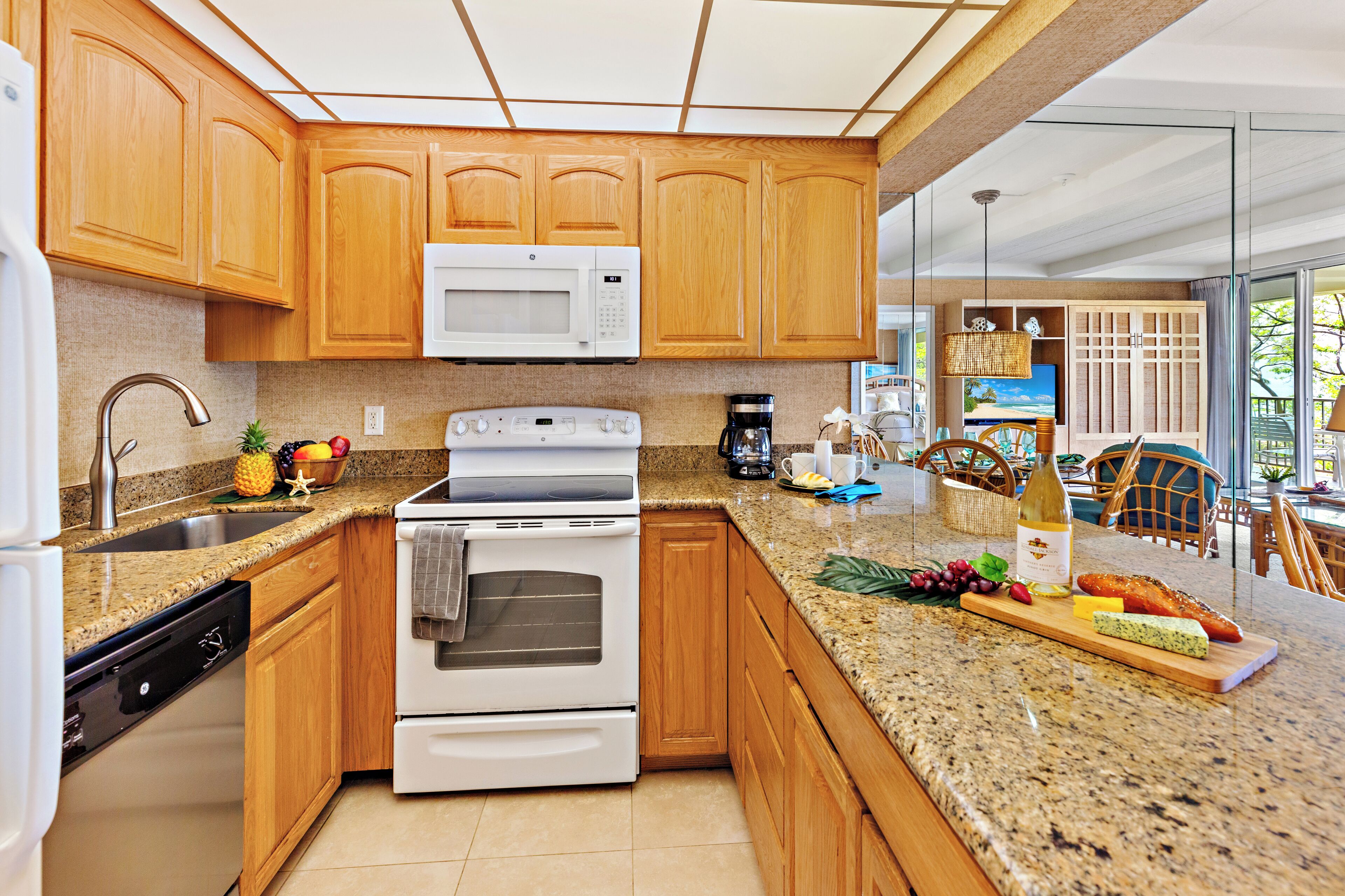 A kitchen with wooden cabinets, a microwave, an oven, and a granite countertop.
