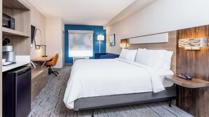 A modern hotel room with a large bed, a desk with a chair, a microwave, and a refrigerator. - Holiday Inn Express & Suites Ormond Beach - North Daytona by IHG (Ormond Beach)