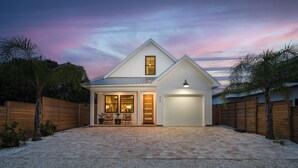 A modern house with a garage, a covered patio, and a well-maintained garden.