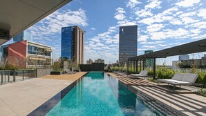 A rooftop pool with lounge chairs and a view of city buildings. - Parque Jockey Pinheiros (São Paulo)
