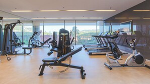 A gym with various exercise equipment, large windows, and a view of the outdoors. - Parque Jockey Pinheiros (São Paulo)