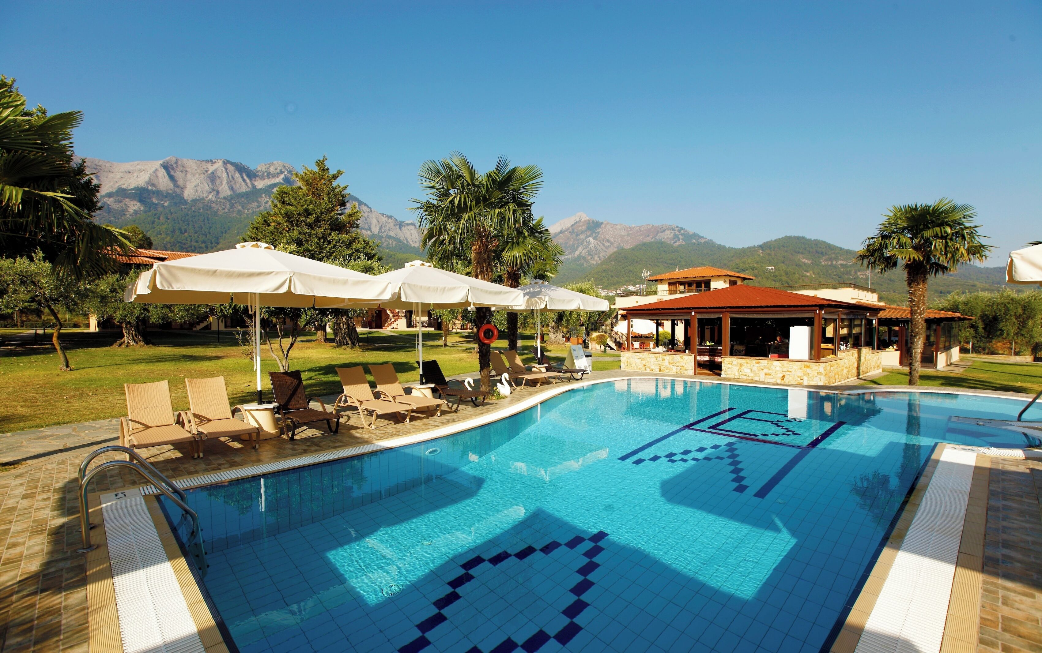 Una piscina al aire libre de temporada, sombrillas