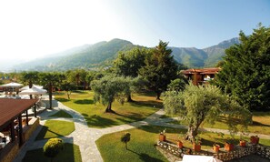 Un resort con un camino de piedra, asientos al aire libre y vistas a montañas.